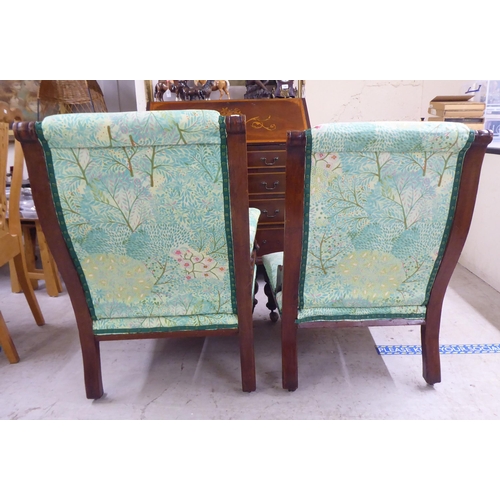 5 - Two matched Edwardian mahogany showwood framed salon chairs, later stud upholstered in floral patter... 