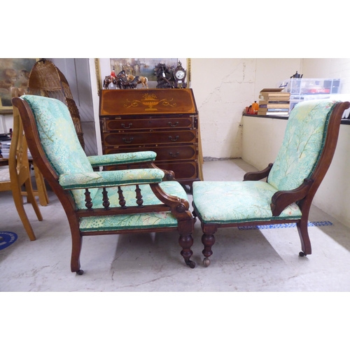 5 - Two matched Edwardian mahogany showwood framed salon chairs, later stud upholstered in floral patter... 