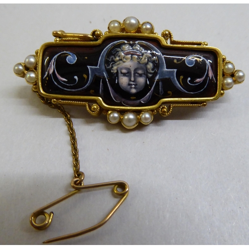 7 - A late Victorian yellow metal mourning brooch with enamelled decoration, set with seed pearls