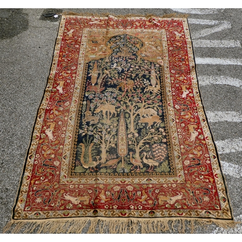 226 - An early 20thC Persian rug, decorated with a central tree of life motif, surrounded by wild animals ... 