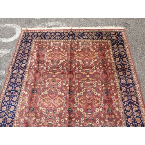 312 - A Persian rug with floral motifs, on a pink ground  77