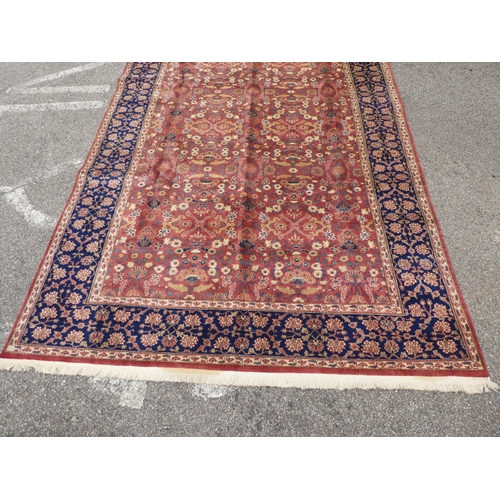 312 - A Persian rug with floral motifs, on a pink ground  77