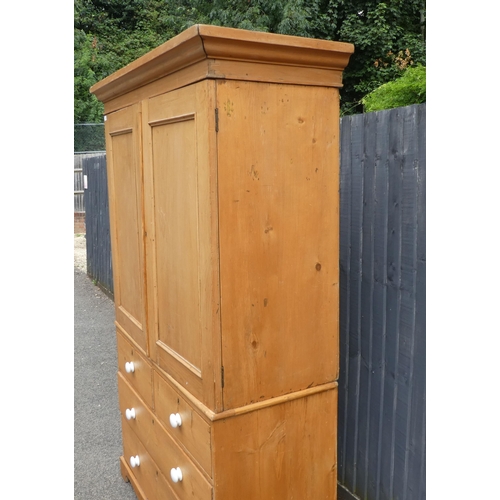 124 - A late Victorian Heal & Son, London pine linen press with a moulded cornice and a pair of panell... 