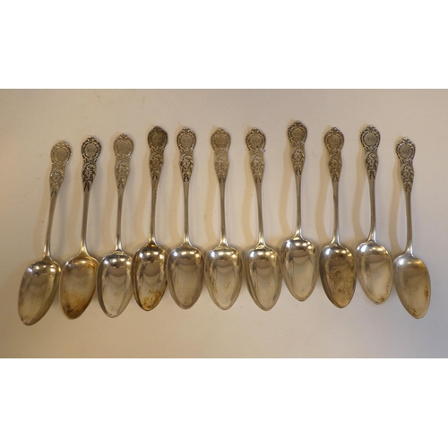 150 - A set of eleven Victorian Scottish silver dessert spoons with ornately cast, scrolled and chased ter... 