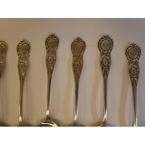 150 - A set of eleven Victorian Scottish silver dessert spoons with ornately cast, scrolled and chased ter... 