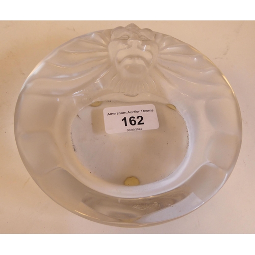 162 - A Lalique part-frosted crystal ashtray 'Tete de Lion'  bears an etched Lalique, France signatur... 