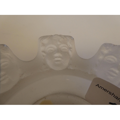 165 - A Lalique part-frosted crystal ashtray 'St Nicholas' with eight cherubic faces  bears an etched... 