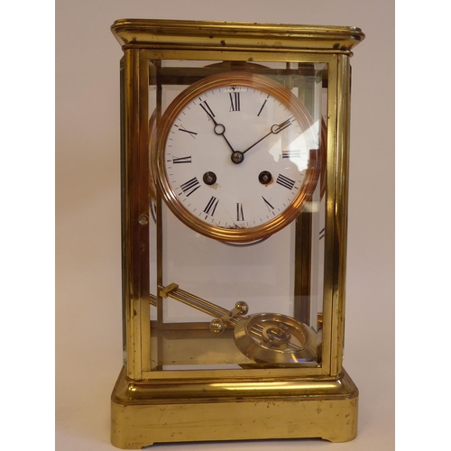 176 - A mid 20thC lacquered brass cased, four glass mantel clock with bevelled panels and a platform top, ... 