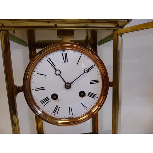 176 - A mid 20thC lacquered brass cased, four glass mantel clock with bevelled panels and a platform top, ... 