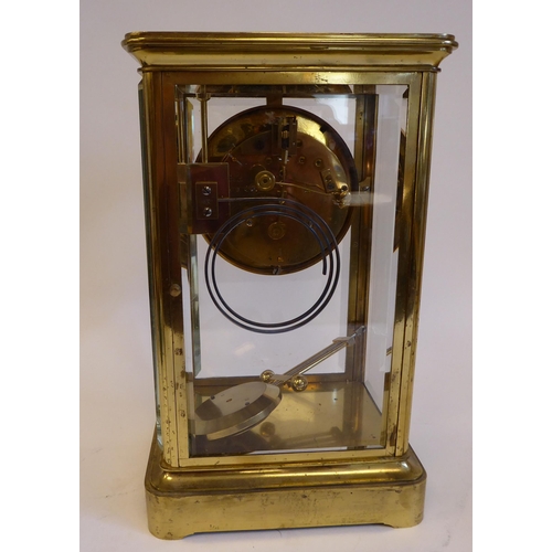 176 - A mid 20thC lacquered brass cased, four glass mantel clock with bevelled panels and a platform top, ... 