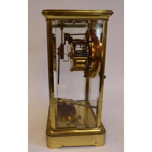 176 - A mid 20thC lacquered brass cased, four glass mantel clock with bevelled panels and a platform top, ... 