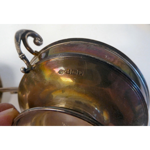 180 - A pair of silver twin handled sweet dishes, on pedestal footrims with glass liners  Rainforth &... 