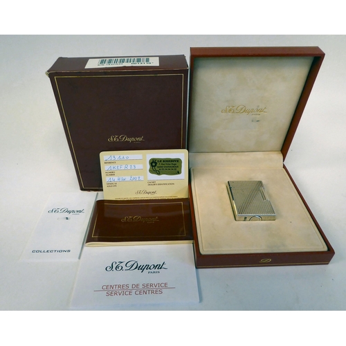 188 - A Dupont gas filled cigarette lighter in textured white metal  impressed IK 2FR23  boxed with certif... 