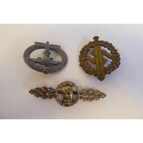 209 - Six World War II German metal and cloth badges and insignia: to include a U Boat badge(Please Note: ... 