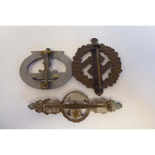 209 - Six World War II German metal and cloth badges and insignia: to include a U Boat badge(Please Note: ... 