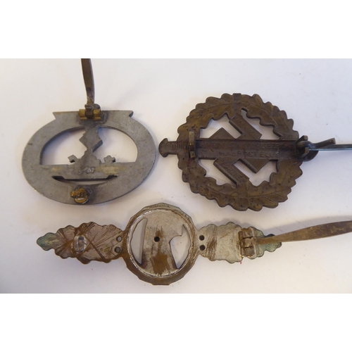 209 - Six World War II German metal and cloth badges and insignia: to include a U Boat badge(Please Note: ... 