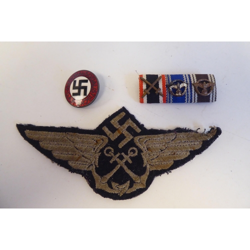 209 - Six World War II German metal and cloth badges and insignia: to include a U Boat badge(Please Note: ... 