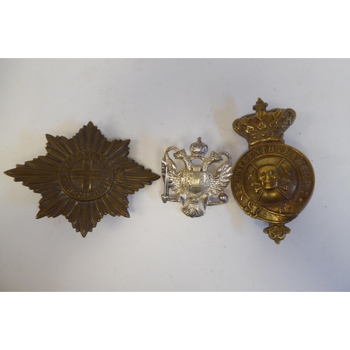 214 - Five military cap badges, some copies: to include a metal example for East Surrey(Please Note: this ... 