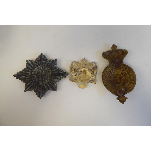 214 - Five military cap badges, some copies: to include a metal example for East Surrey(Please Note: this ... 