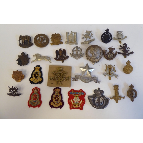 215 - Approximately twenty-seven metal and cloth military cap badges and insignia, some copies: to include... 