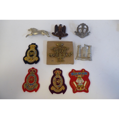 215 - Approximately twenty-seven metal and cloth military cap badges and insignia, some copies: to include... 