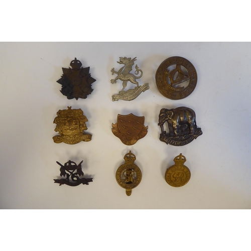 215 - Approximately twenty-seven metal and cloth military cap badges and insignia, some copies: to include... 