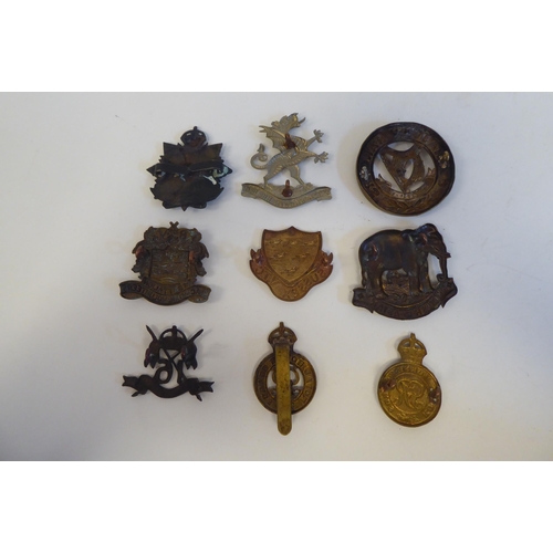 215 - Approximately twenty-seven metal and cloth military cap badges and insignia, some copies: to include... 