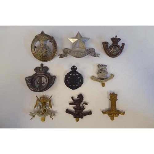 215 - Approximately twenty-seven metal and cloth military cap badges and insignia, some copies: to include... 