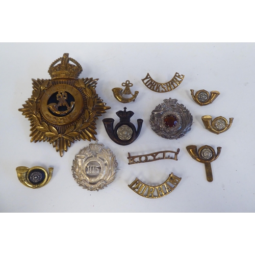 216 - Eleven military Light Infantry metal badges, some copies; and a Durham light Infantry metal helmet p... 