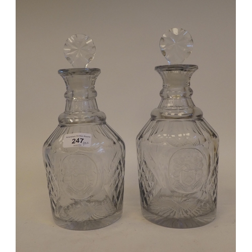 247 - A pair of late Victorian glass decanters with thumb moulded, diamond pattern and armorial cartouches... 