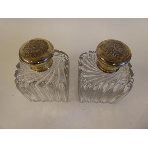 248 - A pair of late 19th/early 20thC clear glass scent bottles of shouldered, ribbed form with rubbed sil... 