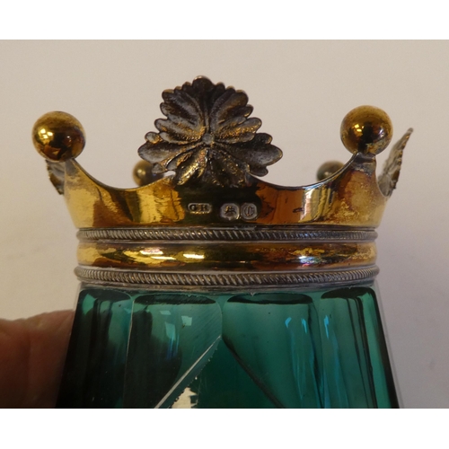 251 - An early Victorian jug shaped bevelled green glass inkwell with a silver gilt mount in the form of a... 