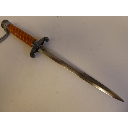 255 - A World War II German officer's dagger with a moulded handle, sheath and silvered thread tie  t... 