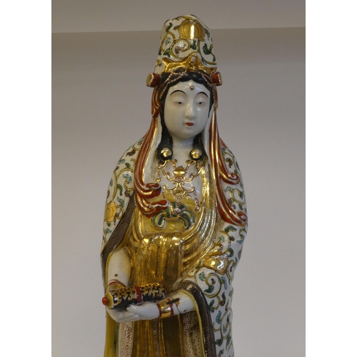 264 - An early 20thC Japanese porcelain figure 'Goddess Kannon' wearing multi-coloured and gilded robes  2... 