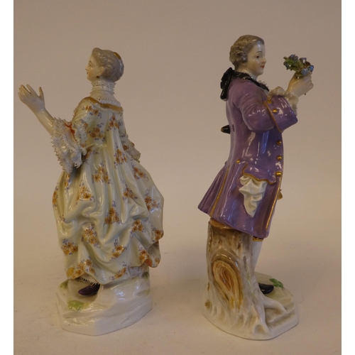 265 - A pair of mid 19thC Meissen porcelain figures, viz. a woman wearing a ballgown, holding a fan  impre... 