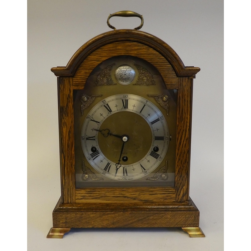 280 - A 20thC Elliot oak cased mantel clock, on a plinth and brass feet; the chiming movement faced by a b... 