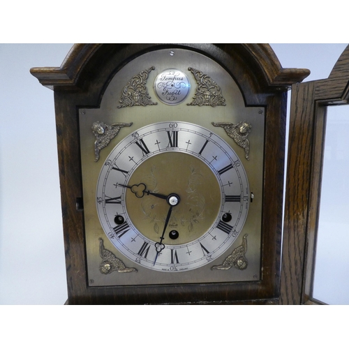 280 - A 20thC Elliot oak cased mantel clock, on a plinth and brass feet; the chiming movement faced by a b... 