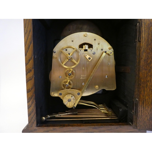 280 - A 20thC Elliot oak cased mantel clock, on a plinth and brass feet; the chiming movement faced by a b... 