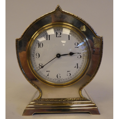 291 - An early/mid 20thC silver plated, cased mantel timepiece, on a bracket plinth; the French movement f... 