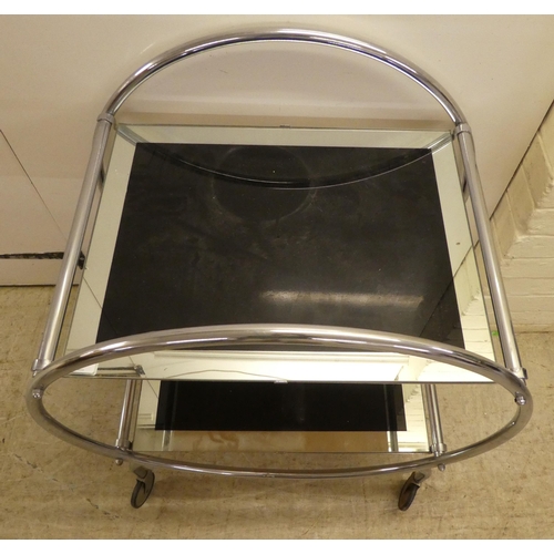 60 - A reproduction of an Art Deco inspired, chromium plated, framed and glazed, two tier hostess trolley... 