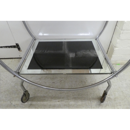 60 - A reproduction of an Art Deco inspired, chromium plated, framed and glazed, two tier hostess trolley... 