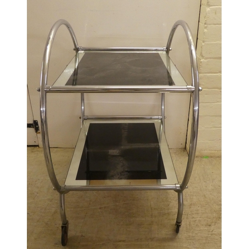 60 - A reproduction of an Art Deco inspired, chromium plated, framed and glazed, two tier hostess trolley... 