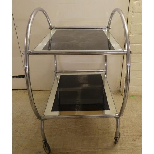 60 - A reproduction of an Art Deco inspired, chromium plated, framed and glazed, two tier hostess trolley... 