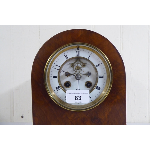 83 - An early 20thC mahogany and walnut finished, cased mantel clock; the 8 day movement faced by a skele... 