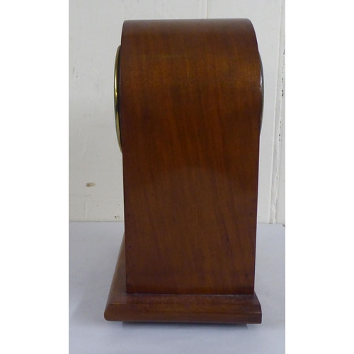 83 - An early 20thC mahogany and walnut finished, cased mantel clock; the 8 day movement faced by a skele... 