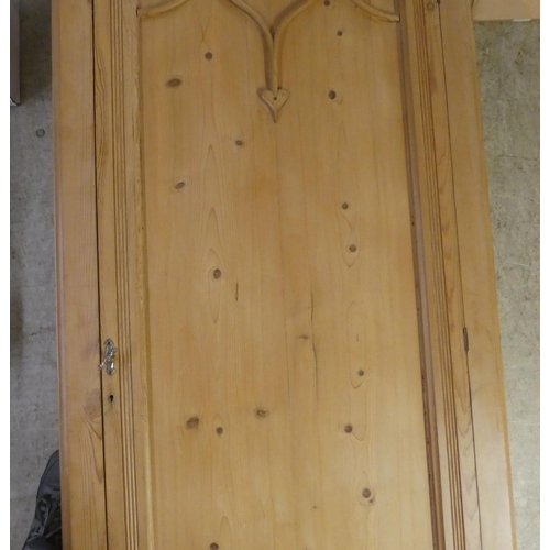 91 - An early 20thC bleached pine wardrobe with a panelled door, on a plinth  78