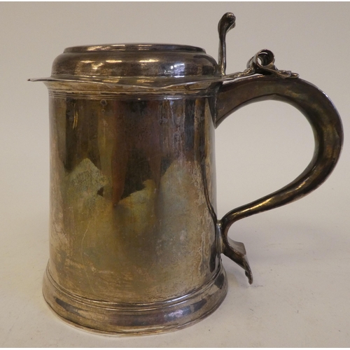 318 - A Queen Anne silver tankard with a hinged lid and an ear shaped handle  London 1706  15.7ozs  5.5