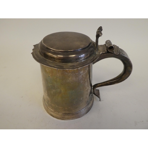 318 - A Queen Anne silver tankard with a hinged lid and an ear shaped handle  London 1706  15.7ozs  5.5