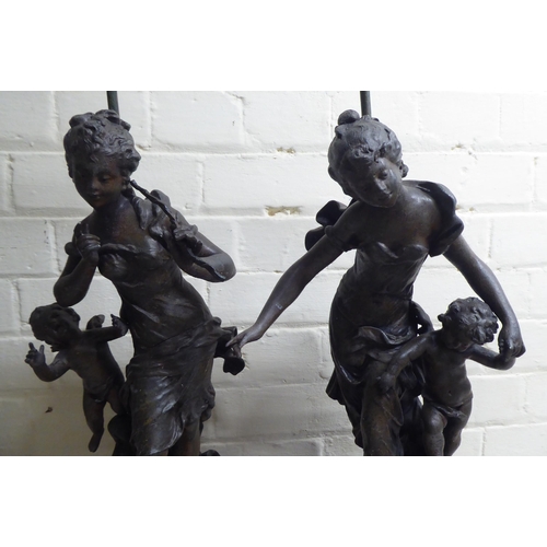 118 - A pair of late 19thC spelter figural lamps, each fashioned as a woman with a cherubic figure  25