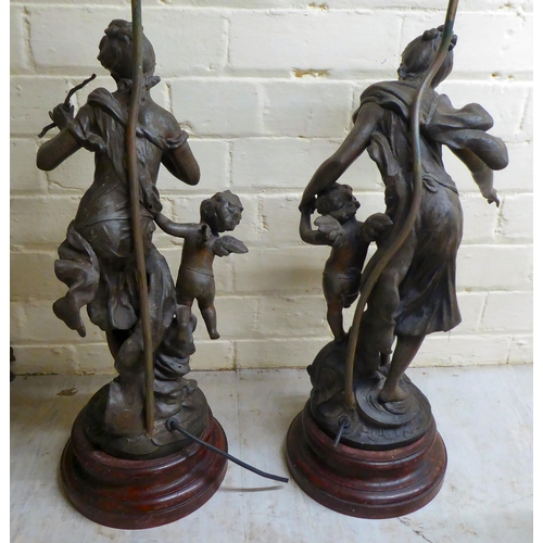 118 - A pair of late 19thC spelter figural lamps, each fashioned as a woman with a cherubic figure  25